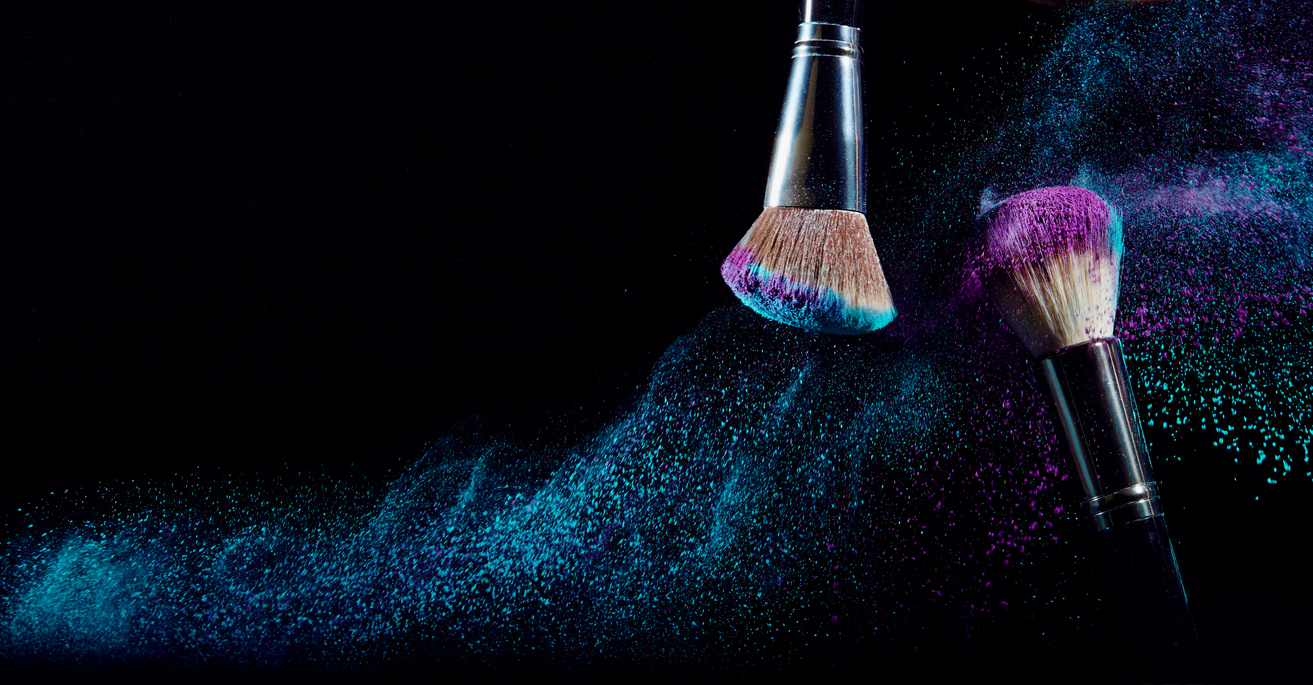 Make-up Brushes with Powder in Dark Background